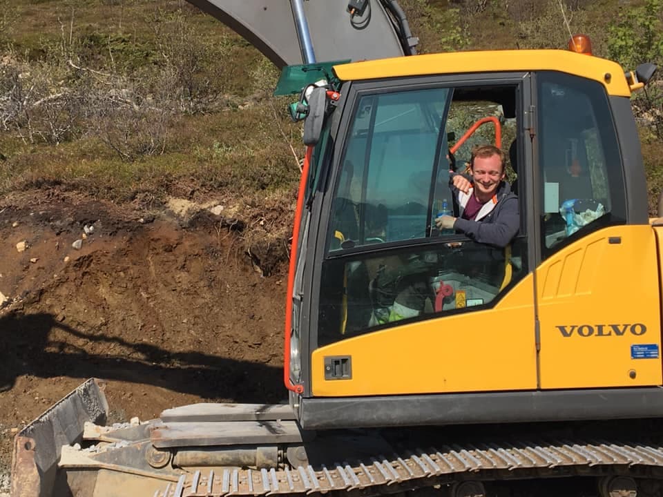 Glad ansatt i gravemaskin på jobb